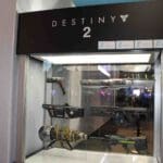 In een vitrinekast worden de wapens uit Destiny 2 als replica getoond.